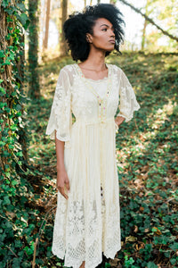 This elegant nightgown is a two-piece set with a lovely silky satin chemise that's worn under a soft, stretchy textured layer of pure golden glamour.  The champagne-colored chemise has adjustable spaghetti straps and falls above the knee. The soft, stretchy overlayer falls low to mid-calf. It's graceful and flowing with three-quarter bell sleeves and waist tie. It's gorgeous ya'll!