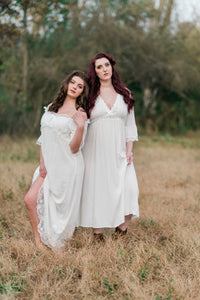 Beautiful, full figured woman in light and airy white nightgown. The gown has three-quarter sleeves with a white embroidered trim, a pretty v-neckline trimmed with white embroidery and an empire waist with embroidered trim.