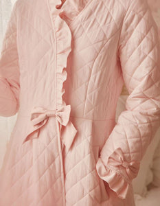 Close up view of Margaret Lawton's Warmth. Ruffled cuffs and collar add a feminine touch, and satin bows at the waist and sleeves transform this winter robe into something quite fancy.