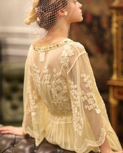Here is a close up image of the back of this elegant nightgown. This elegant nightgown is a two-piece set with a lovely silky satin chemise that's worn under a soft, stretchy textured layer of pure golden glamour.  The champagne-colored chemise has adjustable spaghetti straps and falls above the knee. The soft, stretchy overlayer falls low to mid-calf. It's graceful and flowing with three-quarter bell sleeves and waist tie. It's gorgeous ya'll