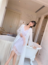 View  of seated woman Margaret Lawton's Dead Gorgeous Peignoir, showing a flowing open robe and a pretty knee length nightgown with a lace hem and lace v-neckline. Beautiful lace trimmed nightgown with long ruffle trimmed chiffon robe.