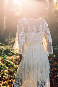 This elegant nightgown is a two-piece set with a lovely silky satin chemise that's worn under a soft, stretchy textured layer of pure golden glamour.  The champagne-colored chemise has adjustable spaghetti straps and falls above the knee. The soft, stretchy overlayer falls low to mid-calf. It's graceful and flowing with three-quarter bell sleeves and waist tie. It's gorgeous ya'll!