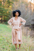 Image of a woman standing with her hands on her hips wearing the Glamorous Lavender Satin Pajamas from Margaret Lawton Nightgowns.