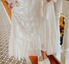 Detail of robe which is made from a soft and stretchy, intricate lace, with embroidered-trim and a ruffled hem. 