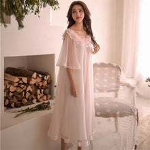 Image of a woman standing wearing a Dreamy Margaret Lawton Nightgown.  Transparent chiffon trimmed with satin ribbon overlays cotton underlayer.
